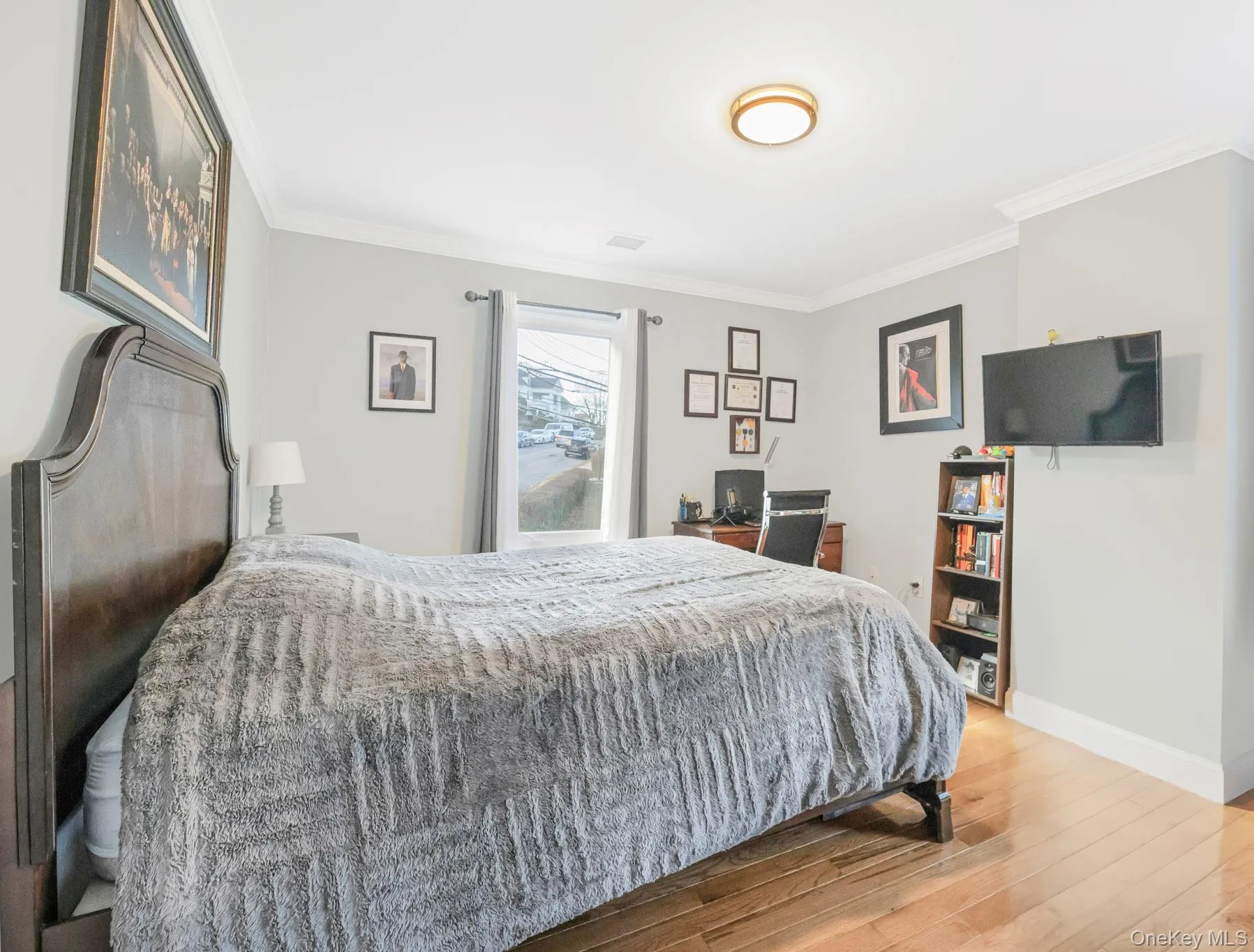 Bedroom featuring ornamental molding and light wood-style floors Bedroom featuring ornamental molding and light wood-style floors