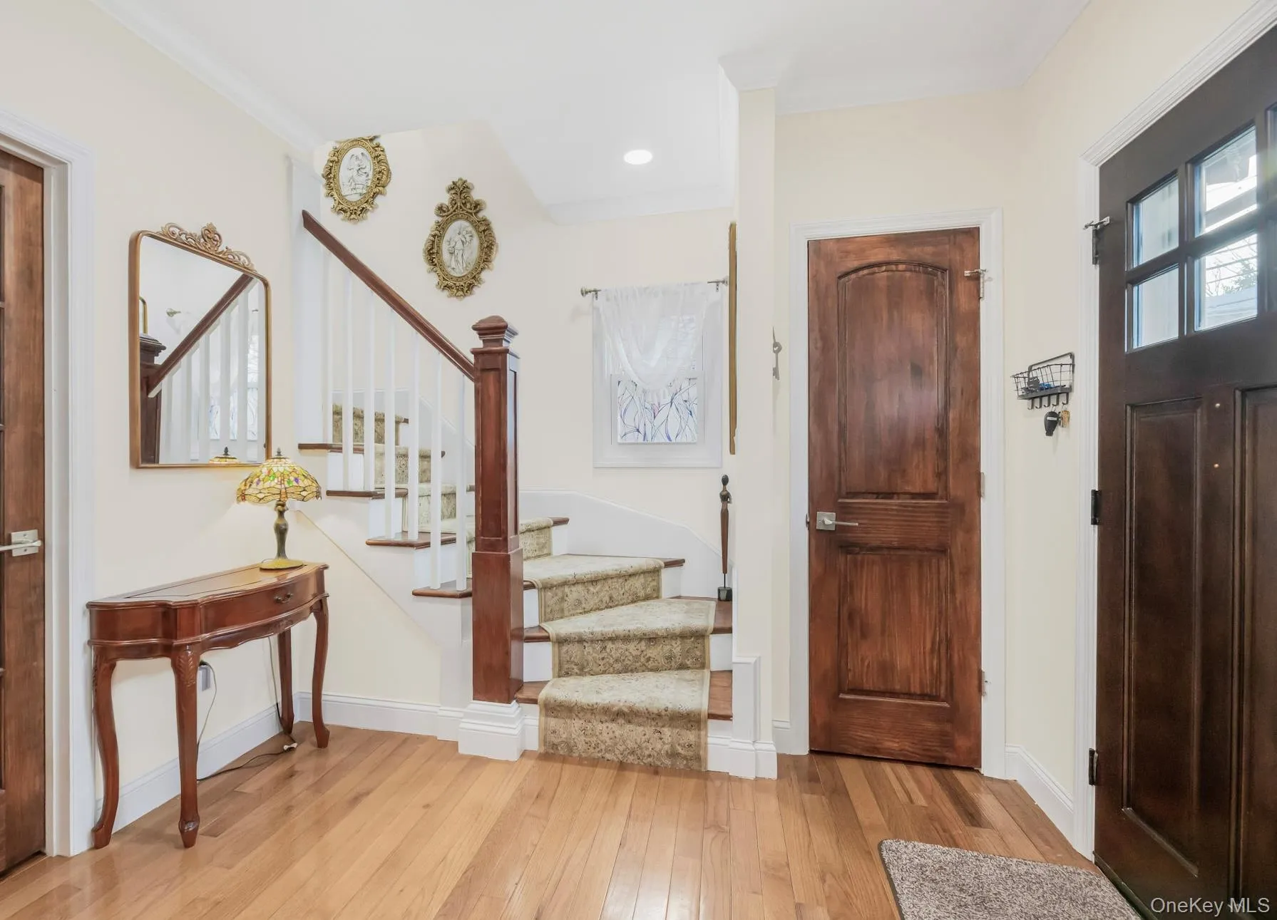 Entryway featuring stairs, light wood-style floors, and crown molding Entryway featuring stairs, light wood-style floors, and crown molding
