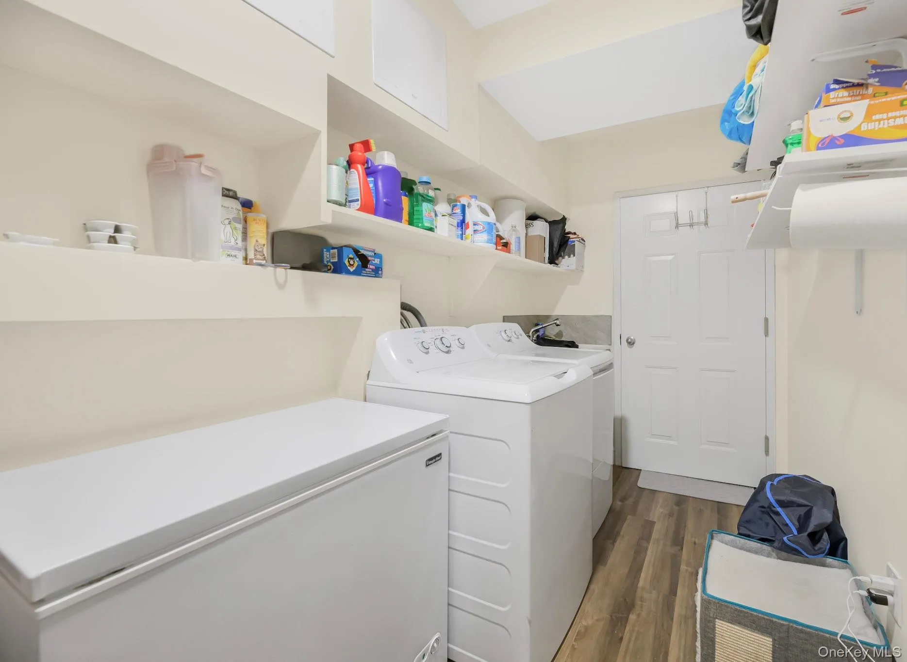 Laundry room featuring dark wood-type flooring and washer and clothes dryer Laundry room featuring dark wood-type flooring and washer and clothes dryer