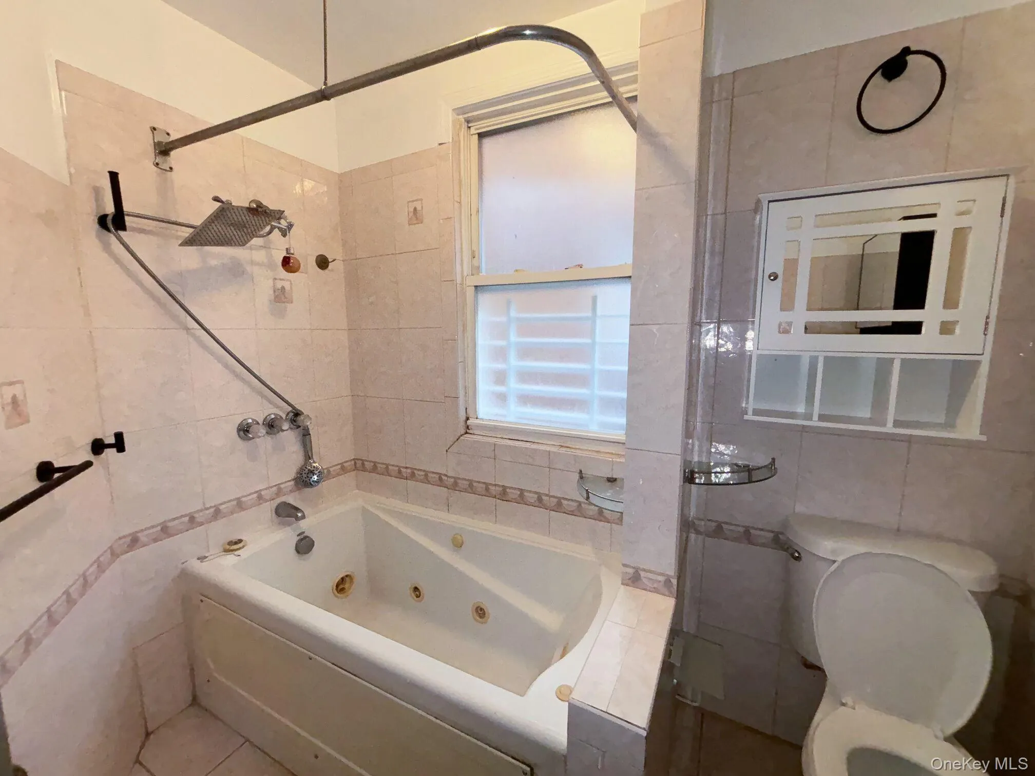 Bathroom with a combined bath / shower with jetted tub and tile walls Bathroom with a combined bath / shower with jetted tub and tile walls