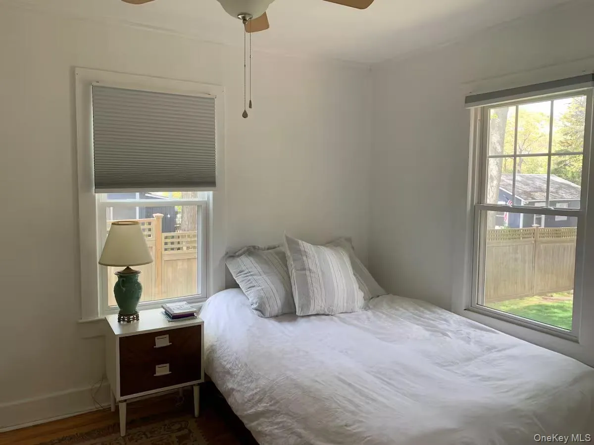 Bedroom with a ceiling fan, wood finished floors, and multiple windows Bedroom with a ceiling fan, wood finished floors, and multiple windows