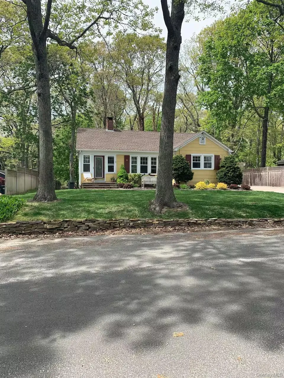 Ranch-style home with a chimney and view of wooded area Ranch-style home with a chimney and view of wooded area