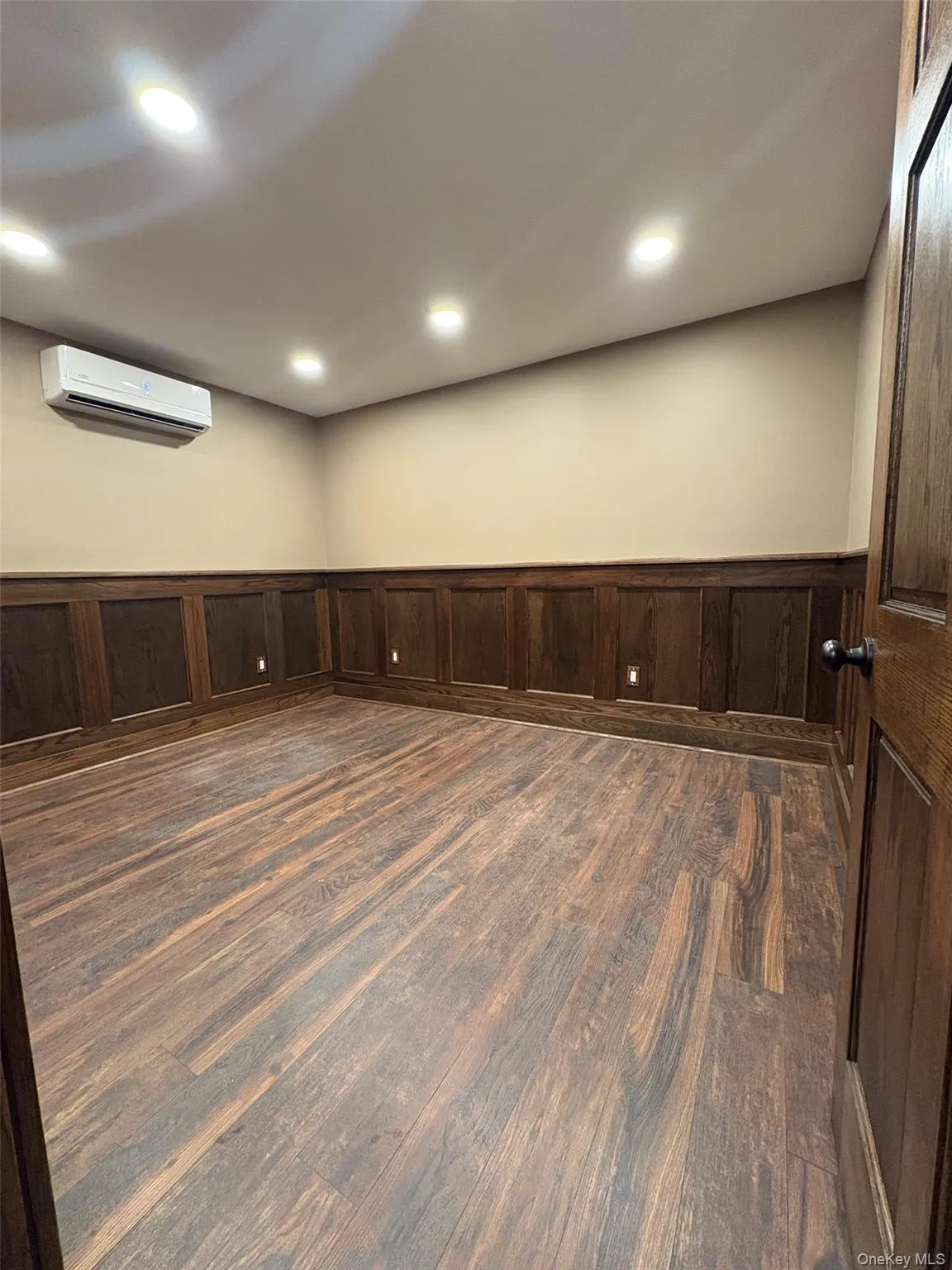 Spare room with wainscoting, dark wood-style flooring, and recessed lighting Spare room with wainscoting, dark wood-style flooring, and recessed lighting