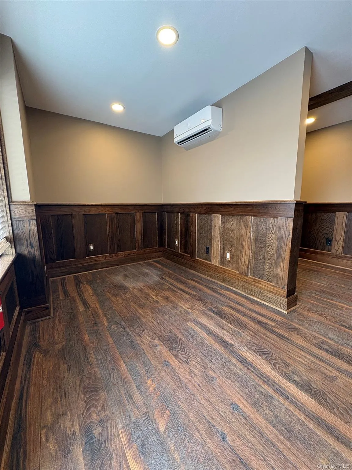 Spare room with a wainscoted wall, recessed lighting, wooden walls, a wall unit AC, and dark wood-style flooring Spare room with a wainscoted wall, recessed lighting, wooden walls, a wall unit AC, and dark wood-style flooring