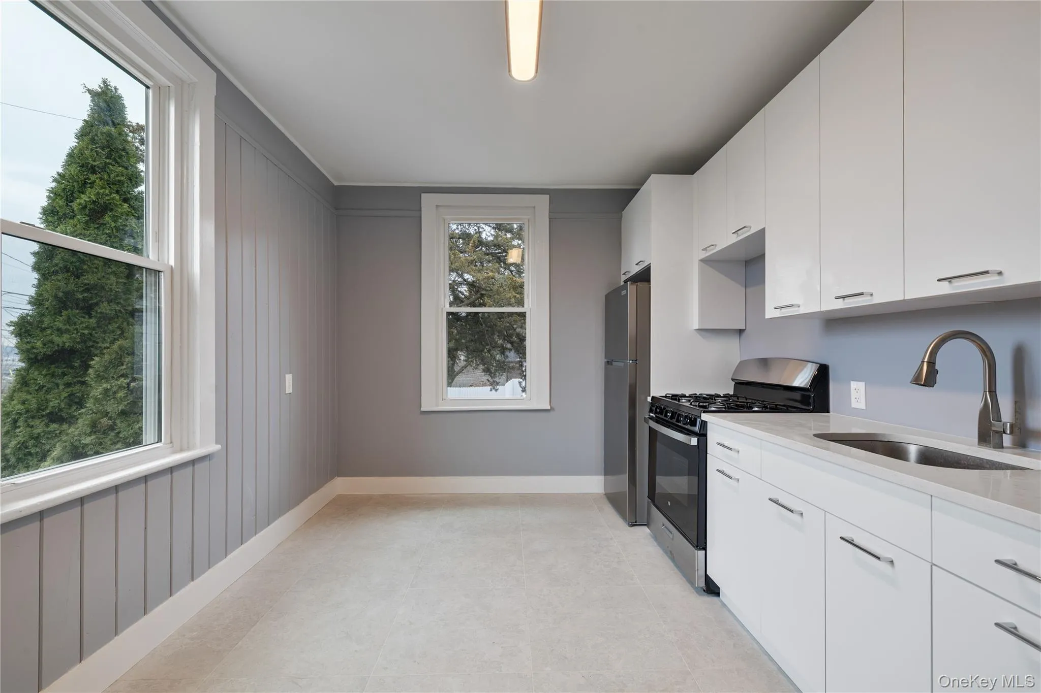 Kitchen featuring a sink, a wealth of natural light, and stainless steel appliances Kitchen featuring a sink, a wealth of natural light, and stainless steel appliances