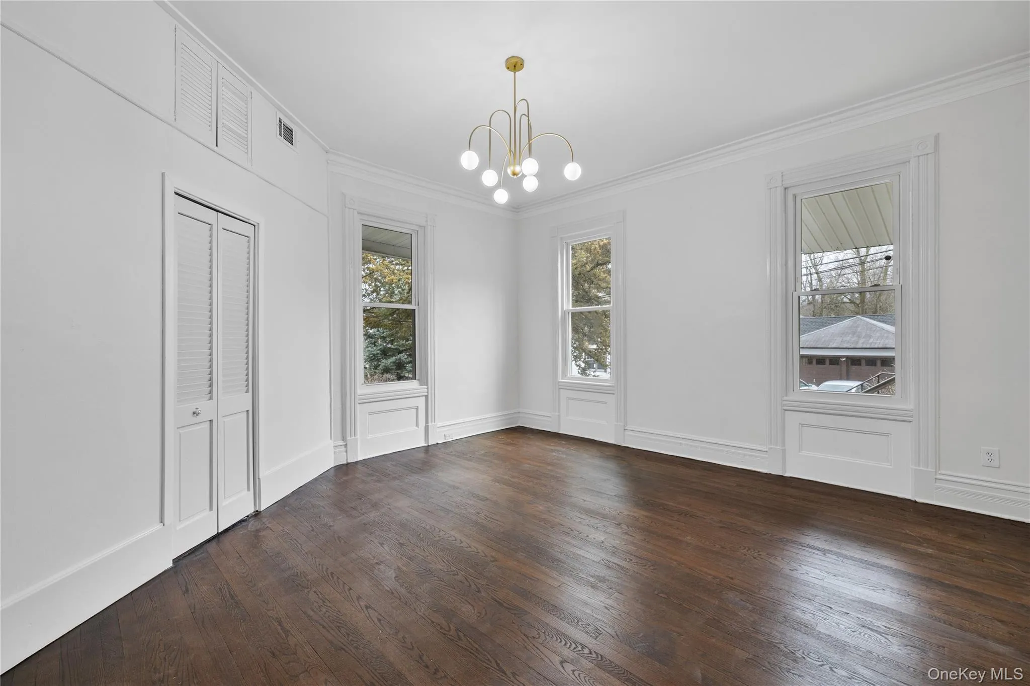 Unfurnished dining area with crown molding, plenty of natural light, a chandelier, and wood finished floors Unfurnished dining area with crown molding, plenty of natural light, a chandelier, and wood finished floors