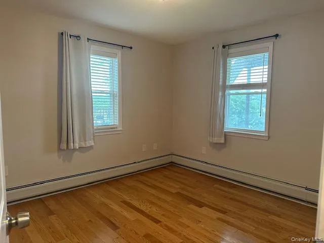 Bedroom with hardwood floors, lots of windows and closet. Bedroom with hardwood floors, lots of windows and closet.