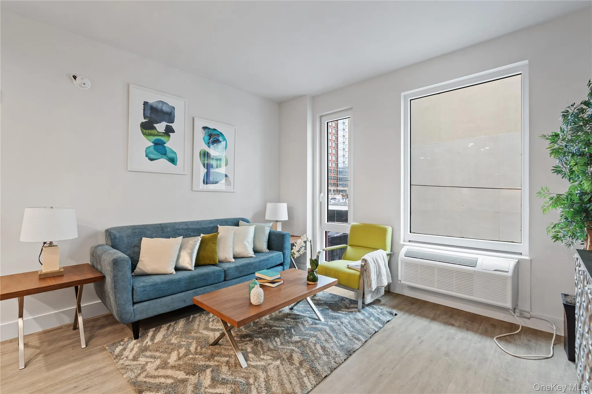 Living room featuring light wood-style floors and a wall mounted air conditioner Living room featuring light wood-style floors and a wall mounted air conditioner