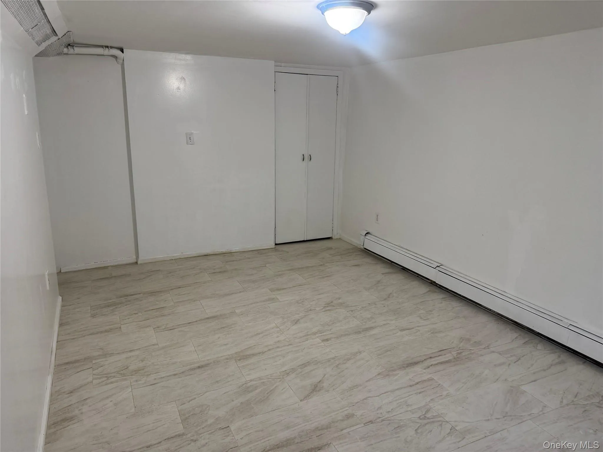 Unfurnished room featuring a baseboard heating unit Unfurnished room featuring a baseboard heating unit