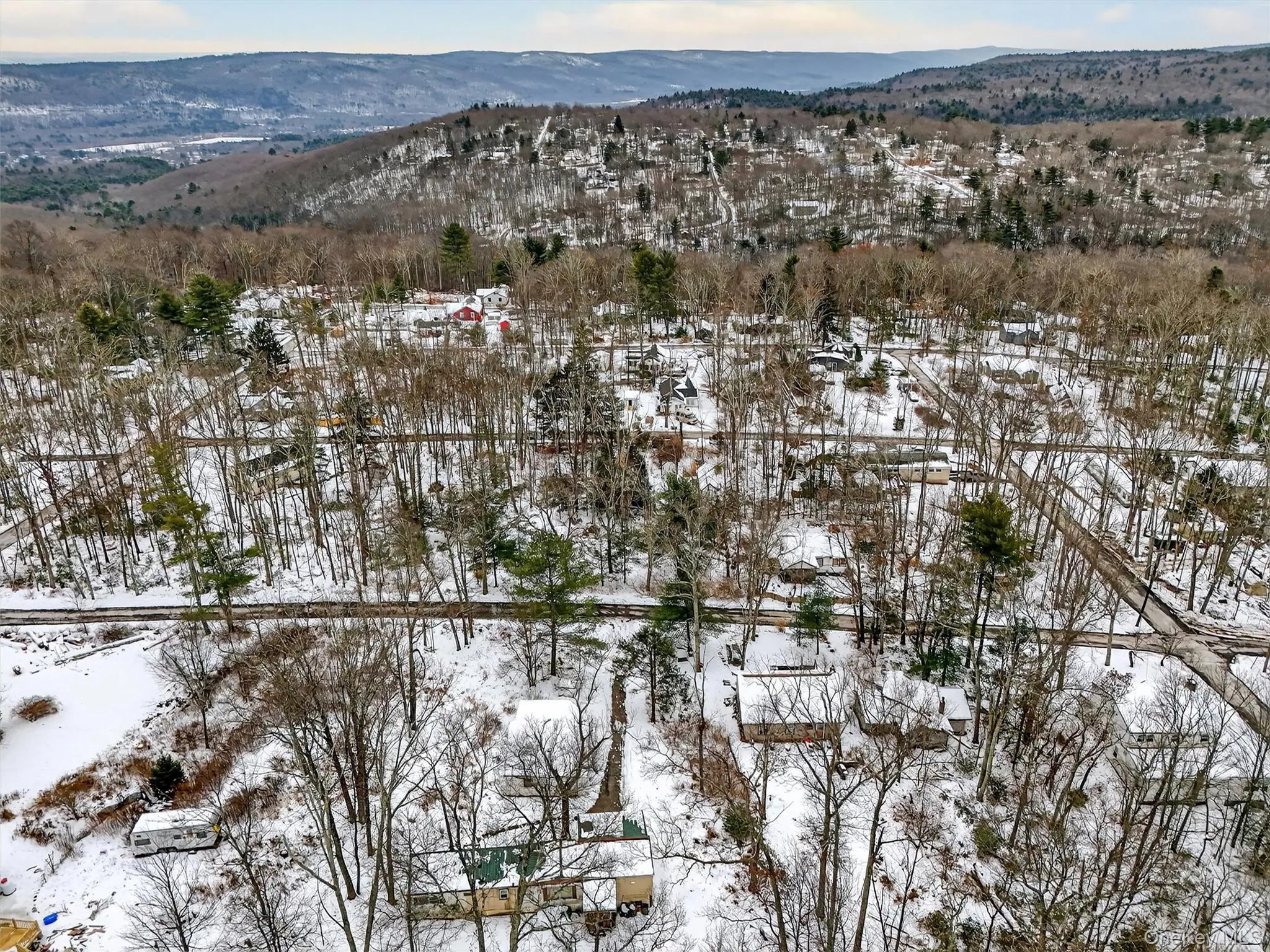Snowy aerial view featuring a mountain view Snowy aerial view featuring a mountain view
