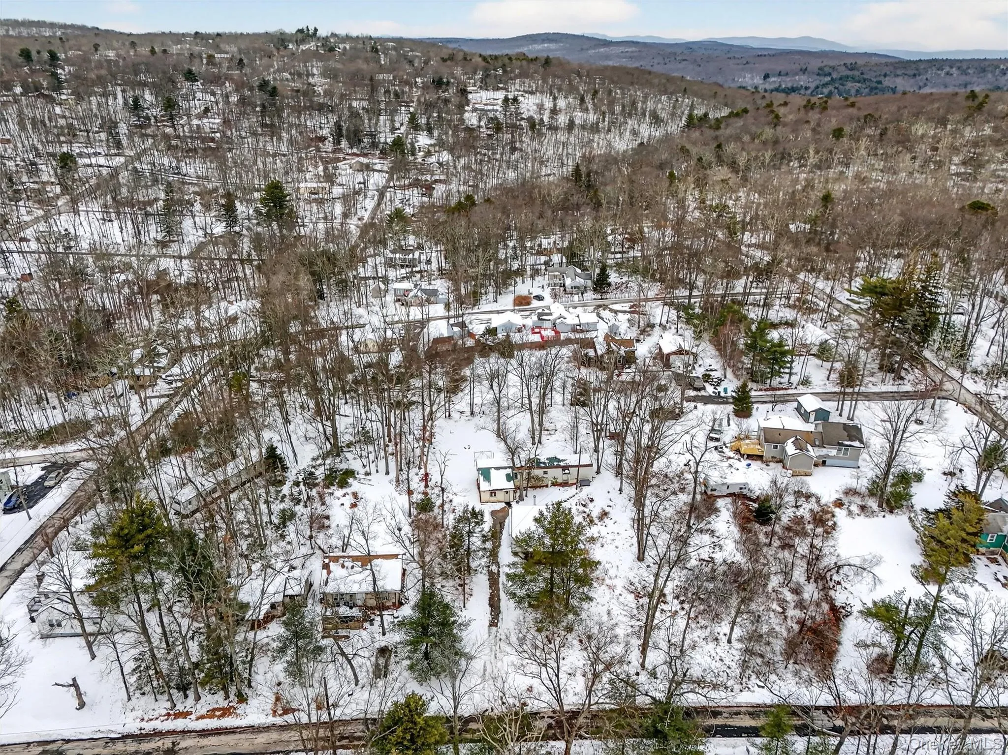 Snowy aerial view featuring a mountain view Snowy aerial view featuring a mountain view