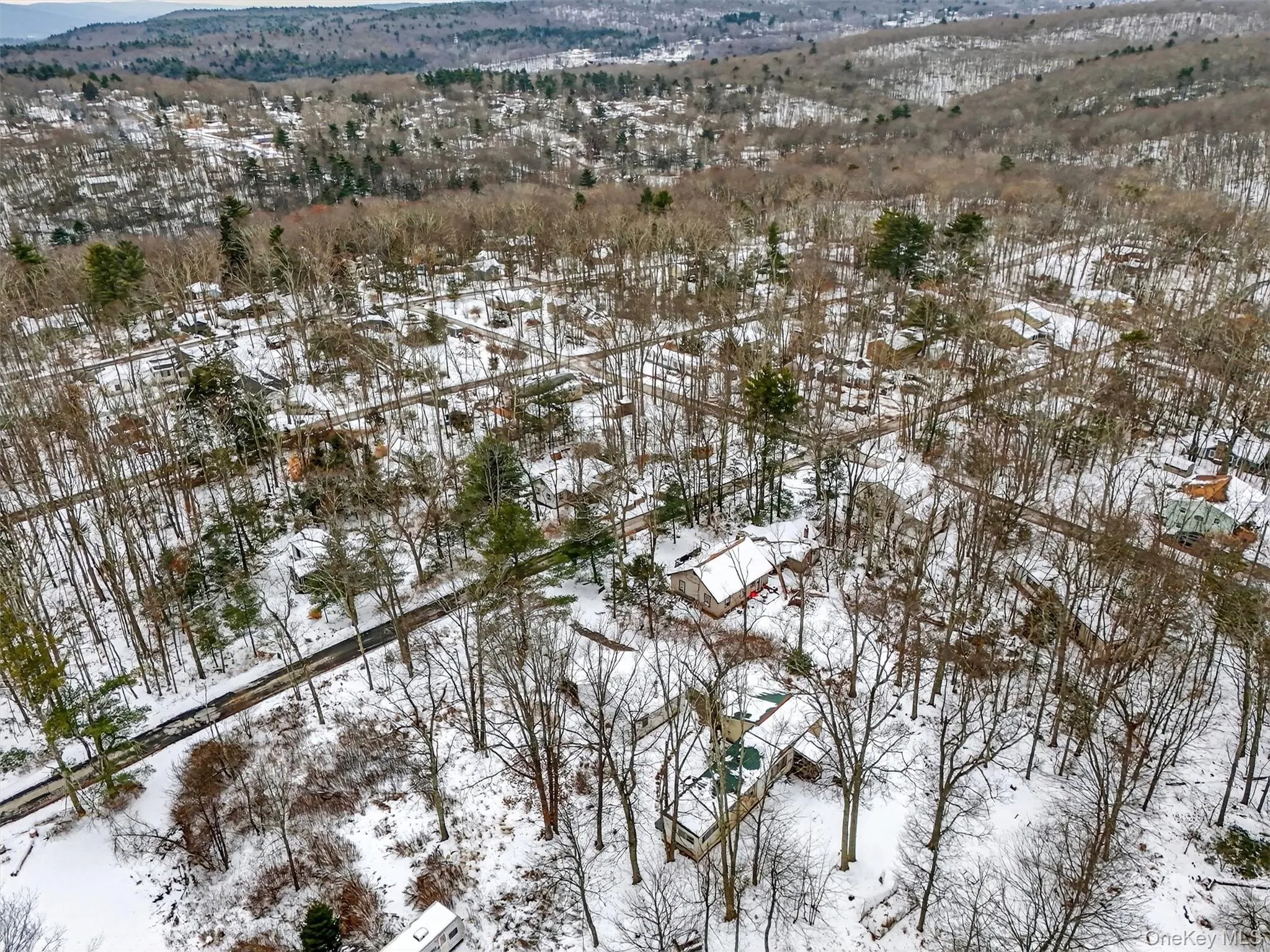 Snowy aerial view featuring a mountain view Snowy aerial view featuring a mountain view