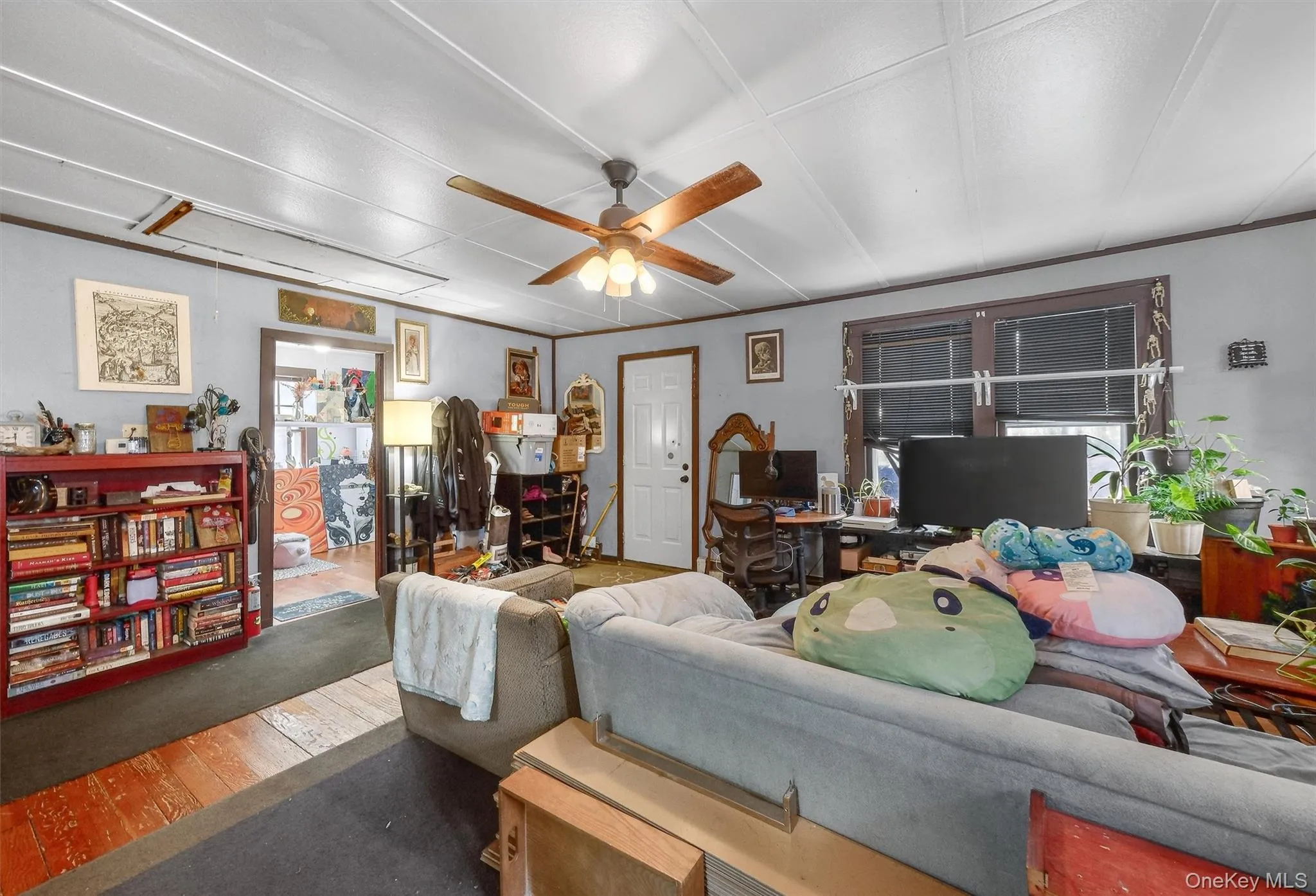 Living room featuring attic access, ceiling fan, wood-type flooring, and an office area Living room featuring attic access, ceiling fan, wood-type flooring, and an office area