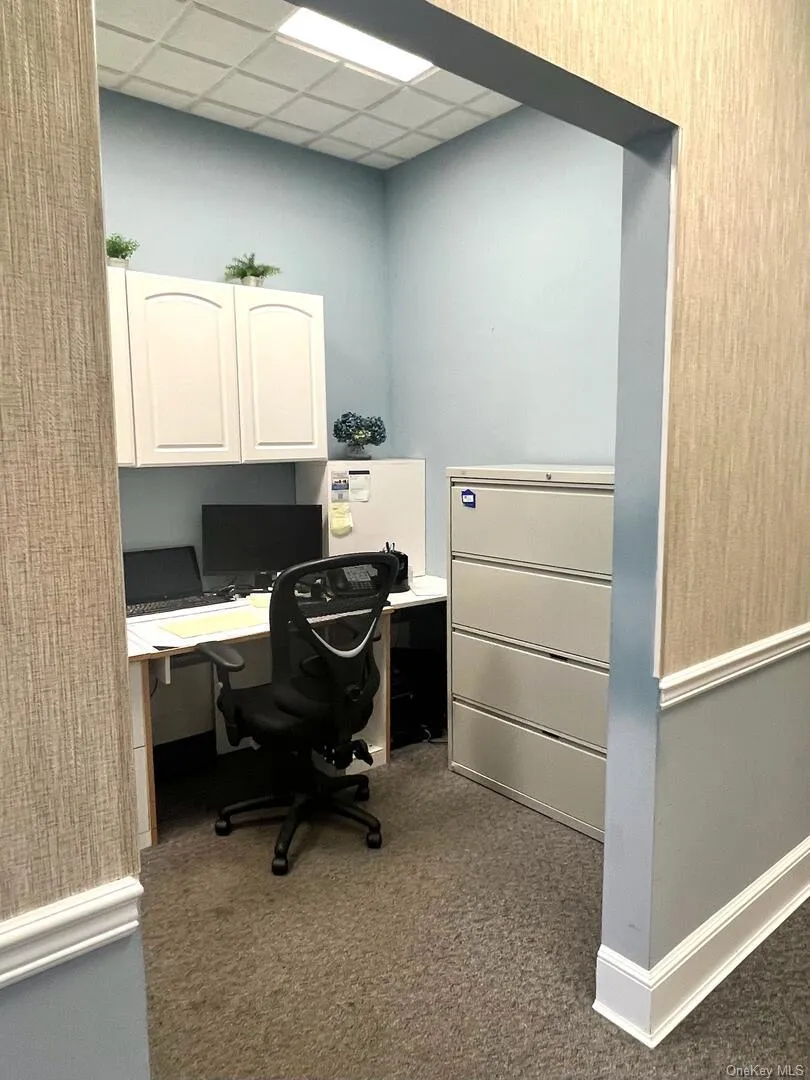 Office featuring dark carpet and a drop ceiling Office featuring dark carpet and a drop ceiling