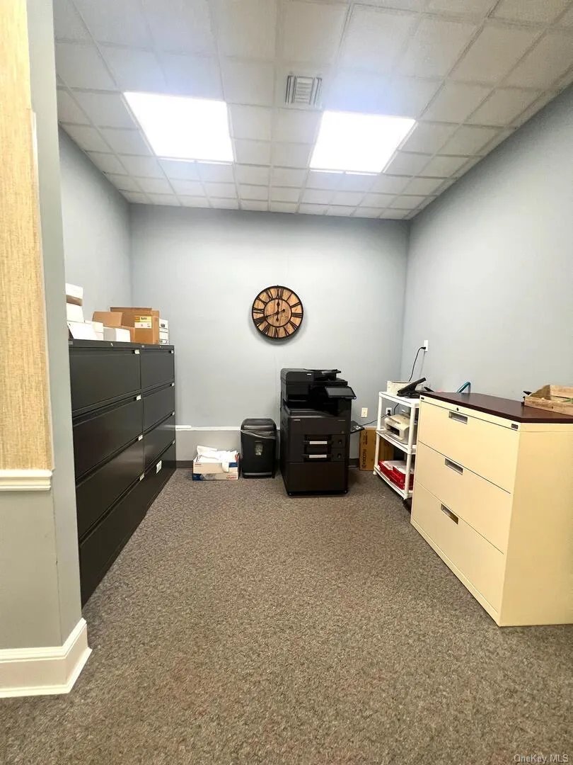 Misc room with dark colored carpet and a drop ceiling Misc room with dark colored carpet and a drop ceiling