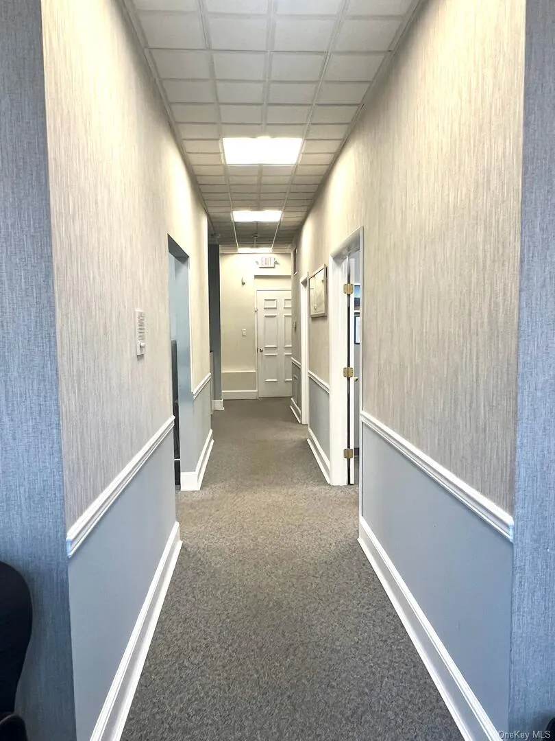 Corridor with carpet floors and baseboards Corridor with carpet floors and baseboards