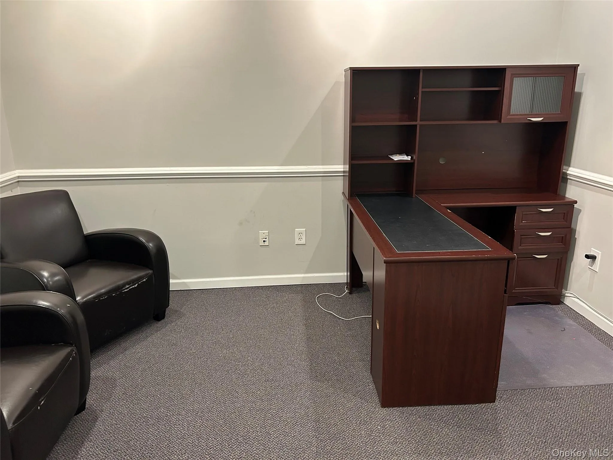 Unfurnished office featuring dark carpet and baseboards Unfurnished office featuring dark carpet and baseboards