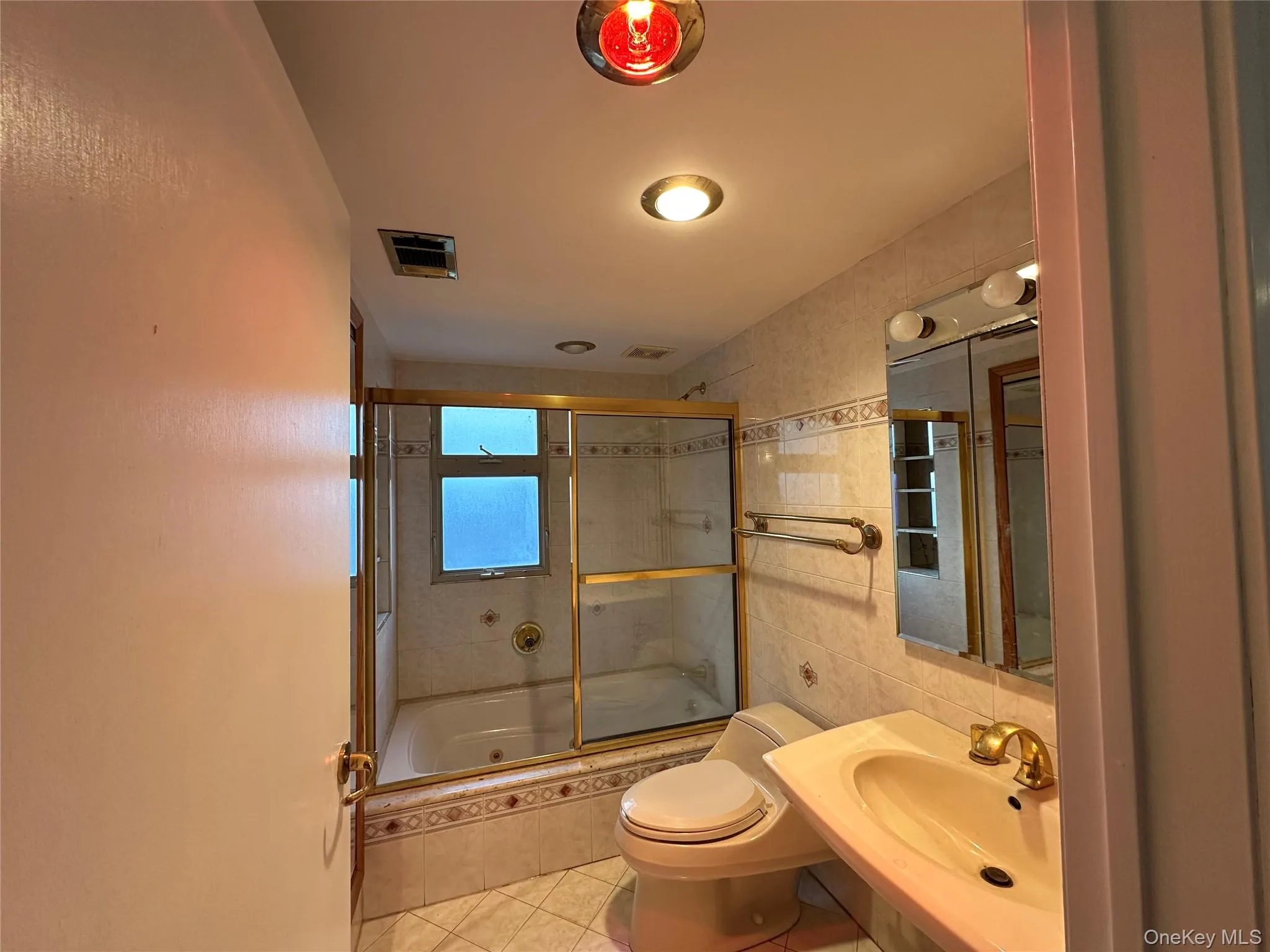 Full bathroom with tiled shower / bath combo and light tile patterned floors Full bathroom with tiled shower / bath combo and light tile patterned floors
