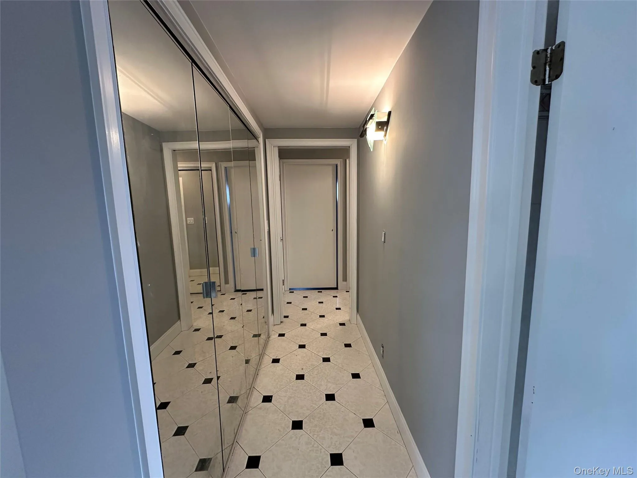 Hall with tile patterned floors and baseboards Hall with tile patterned floors and baseboards