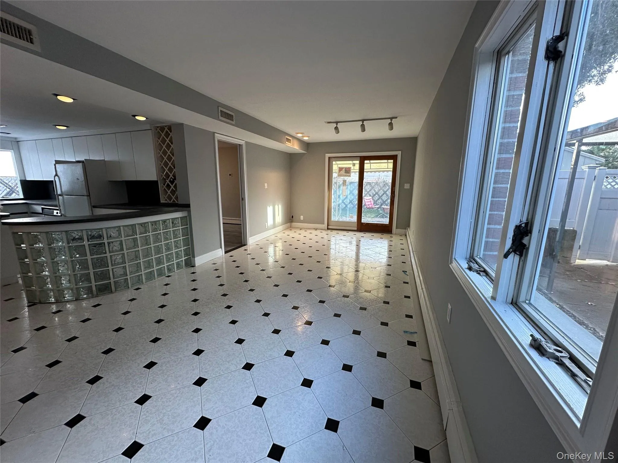 Unfurnished living room featuring light tile patterned floors and track lighting Unfurnished living room featuring light tile patterned floors and track lighting