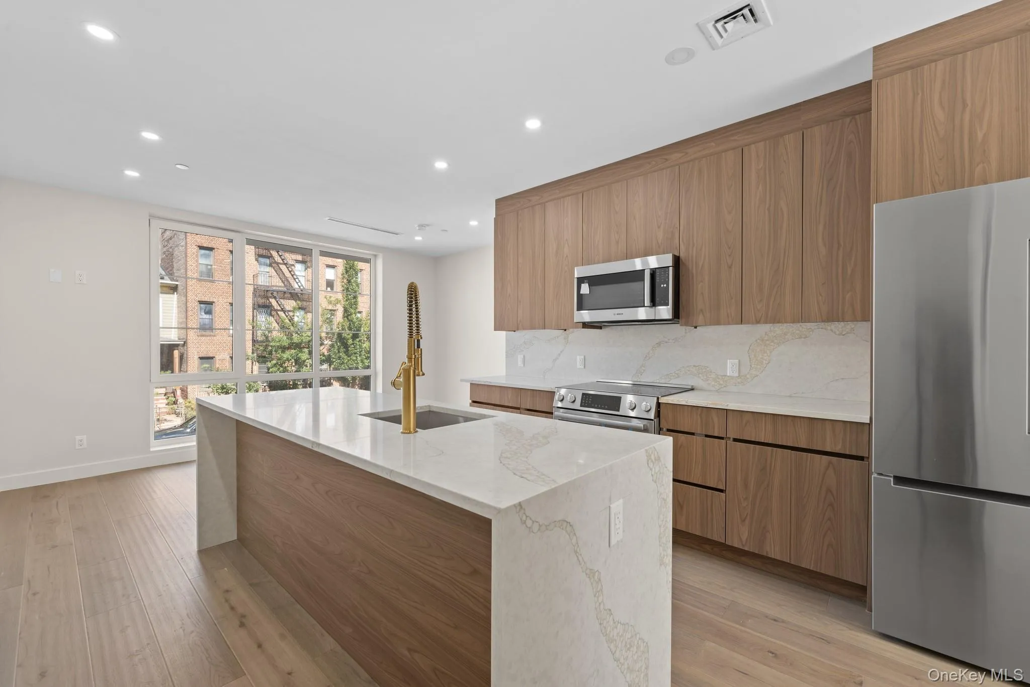 Kitchen with appliances with stainless steel finishes, recessed lighting, light stone counters, brown cabinets, and modern cabinets Kitchen with appliances with stainless steel finishes, recessed lighting, light stone counters, brown cabinets, and modern cabinets