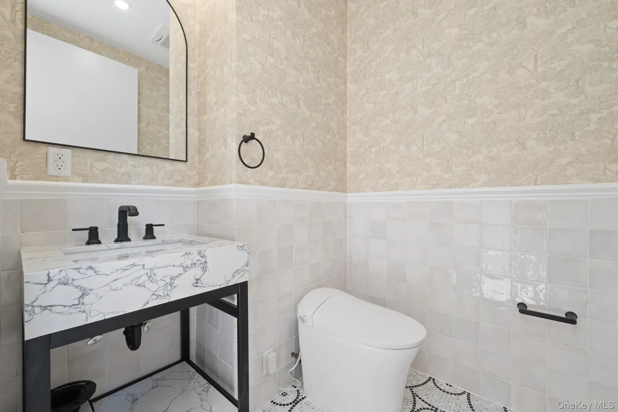 Bathroom with a wainscoted wall and tile walls Bathroom with a wainscoted wall and tile walls
