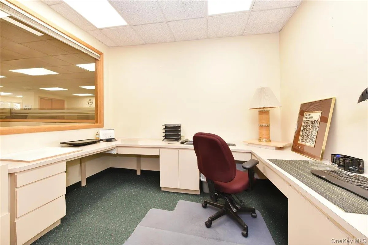 Office space with a paneled ceiling and built in study area Office space with a paneled ceiling and built in study area