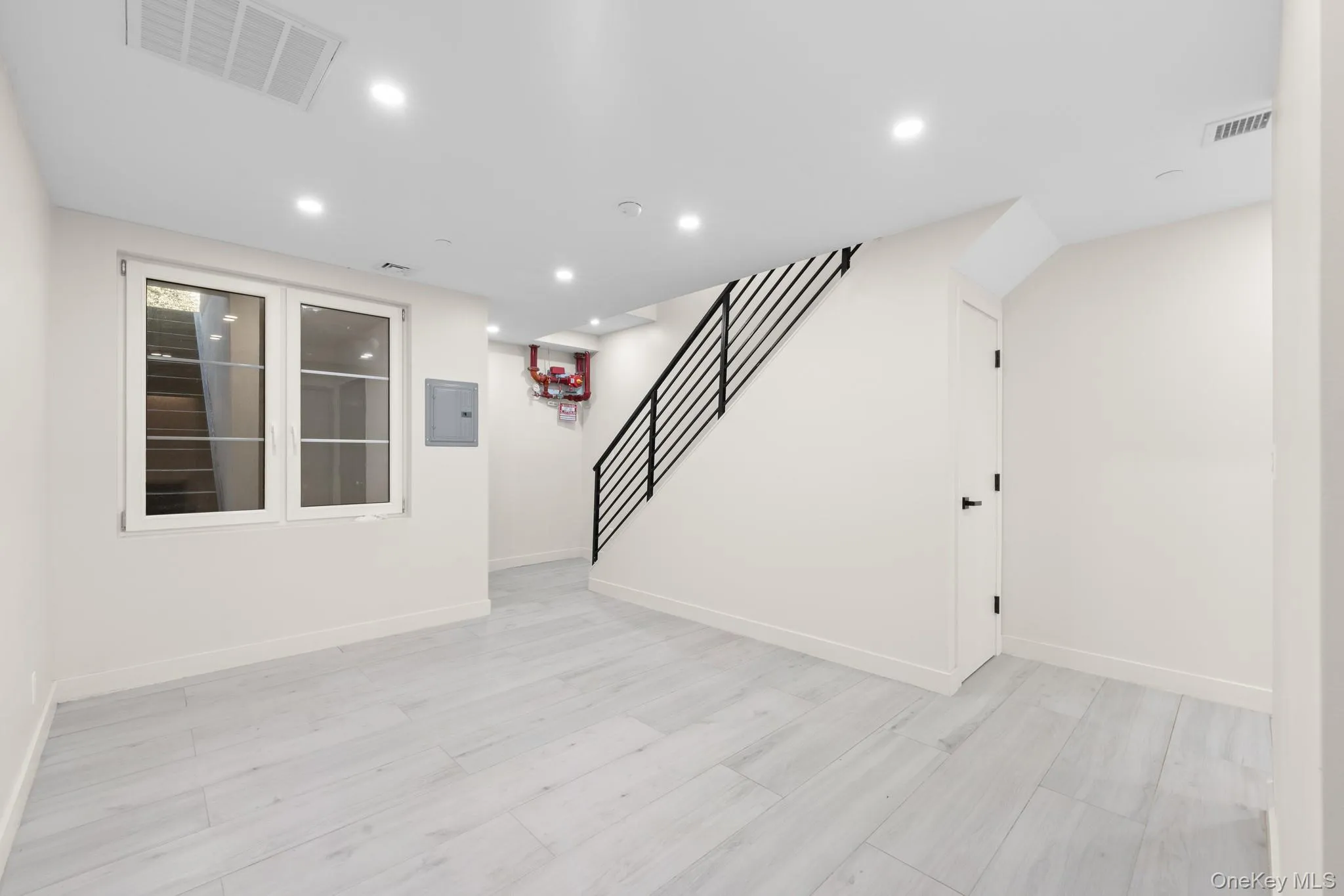 Finished below grade area with recessed lighting, stairway, and electric panel Finished below grade area with recessed lighting, stairway, and electric panel