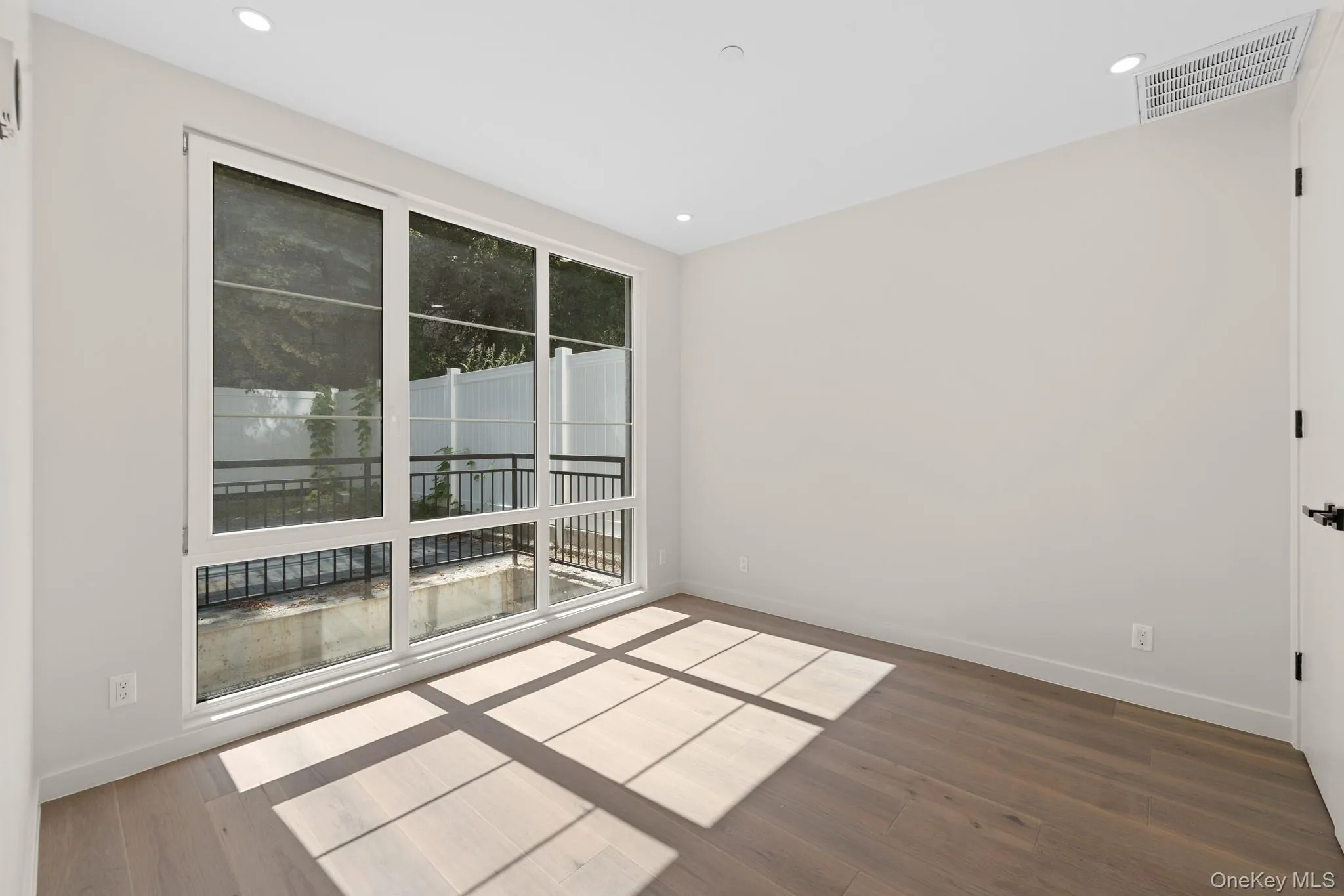 Spare room featuring dark wood-type flooring and recessed lighting Spare room featuring dark wood-type flooring and recessed lighting