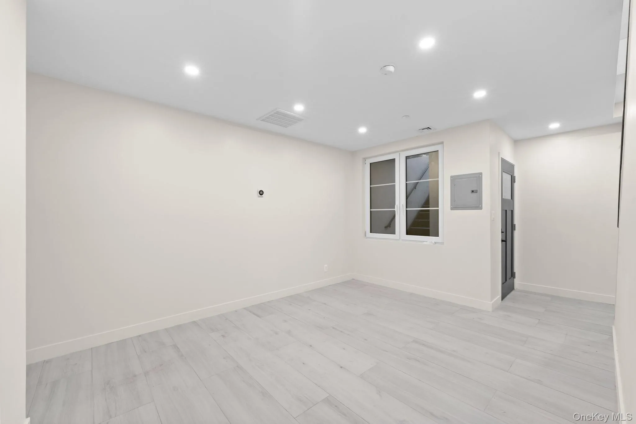 Unfurnished room with recessed lighting, electric panel, and light wood-type flooring Unfurnished room with recessed lighting, electric panel, and light wood-type flooring