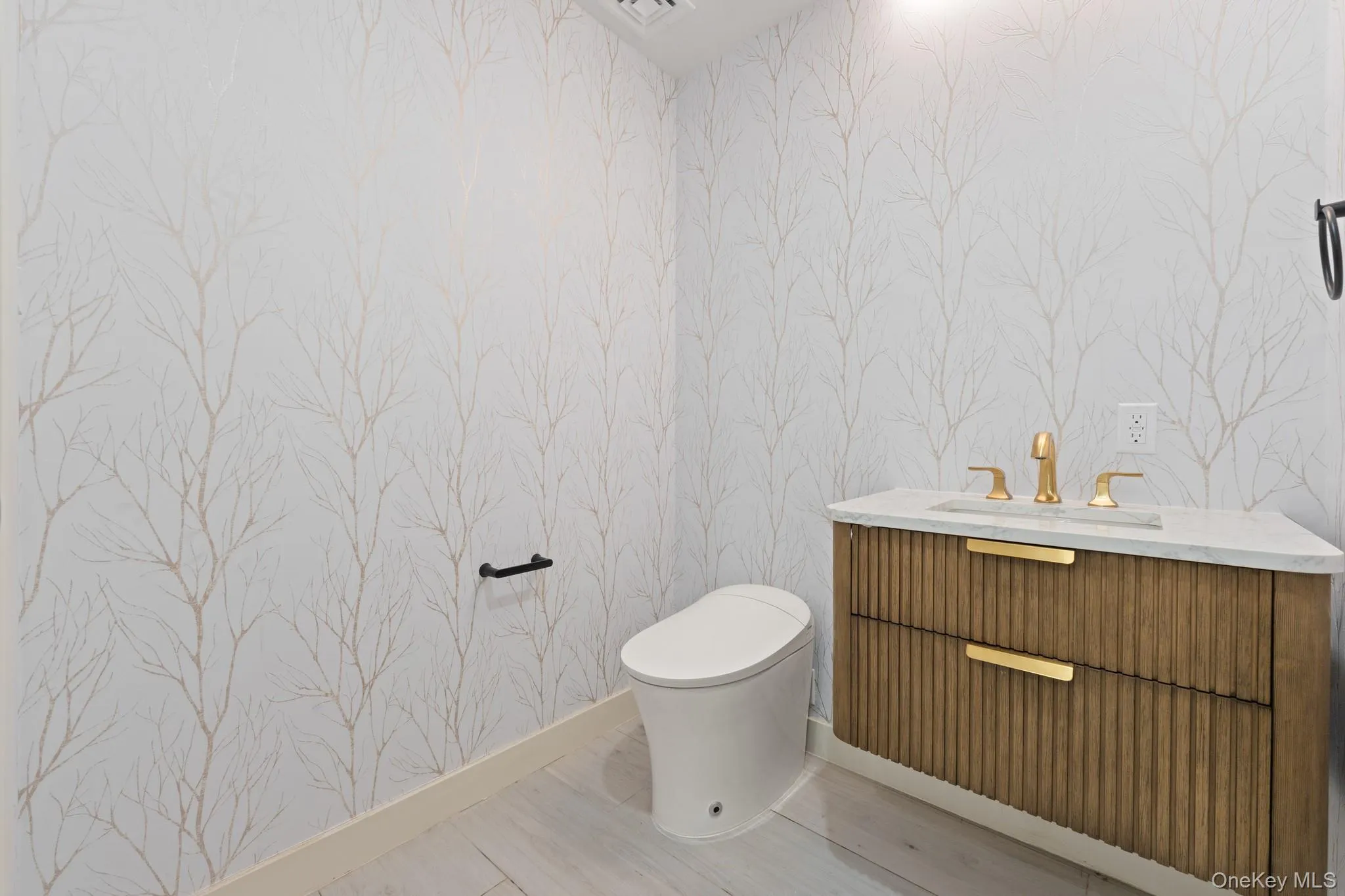 Bathroom with wallpapered walls and vanity Bathroom with wallpapered walls and vanity