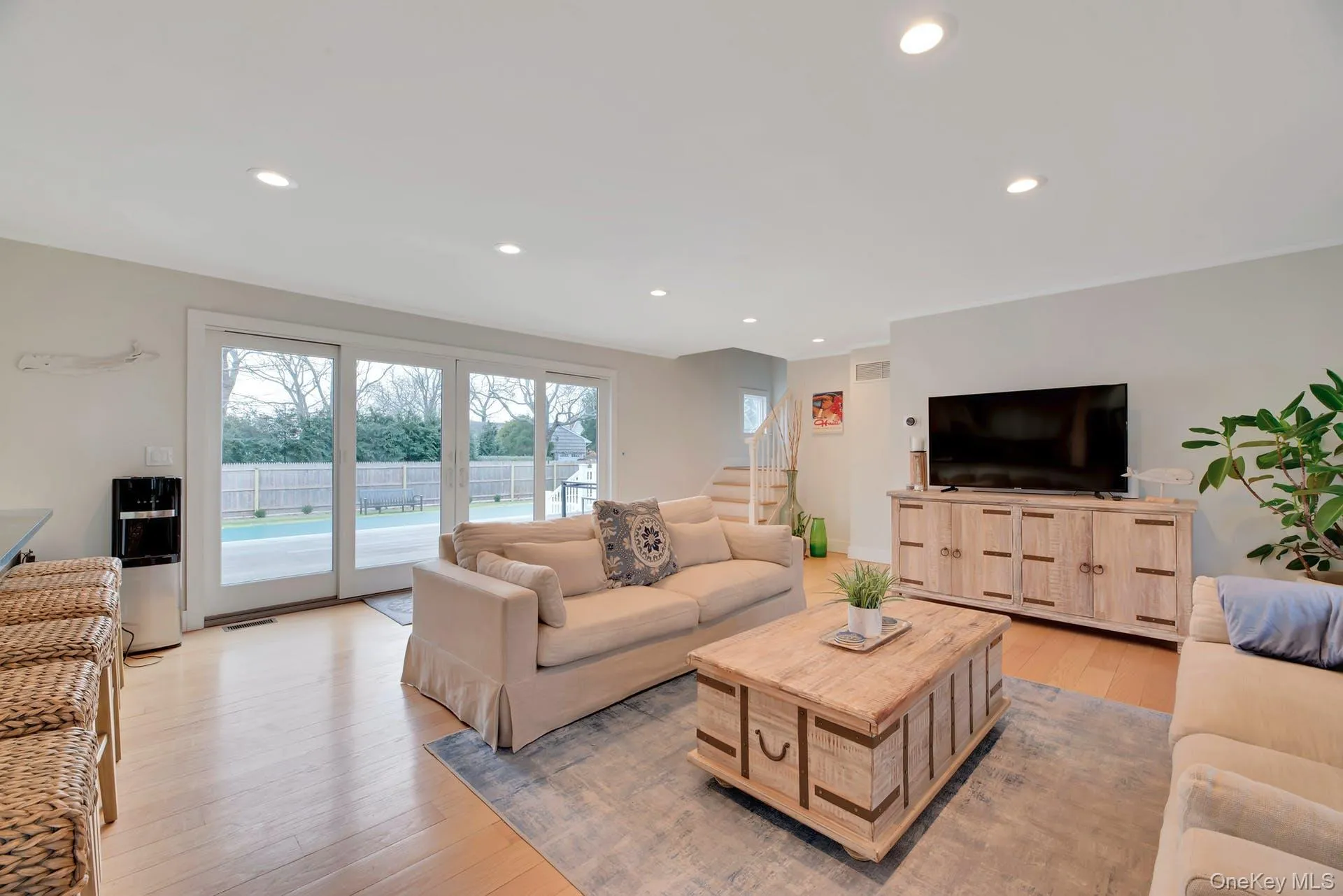 Living area with light wood finished floors, stairway, and recessed lighting Living area with light wood finished floors, stairway, and recessed lighting