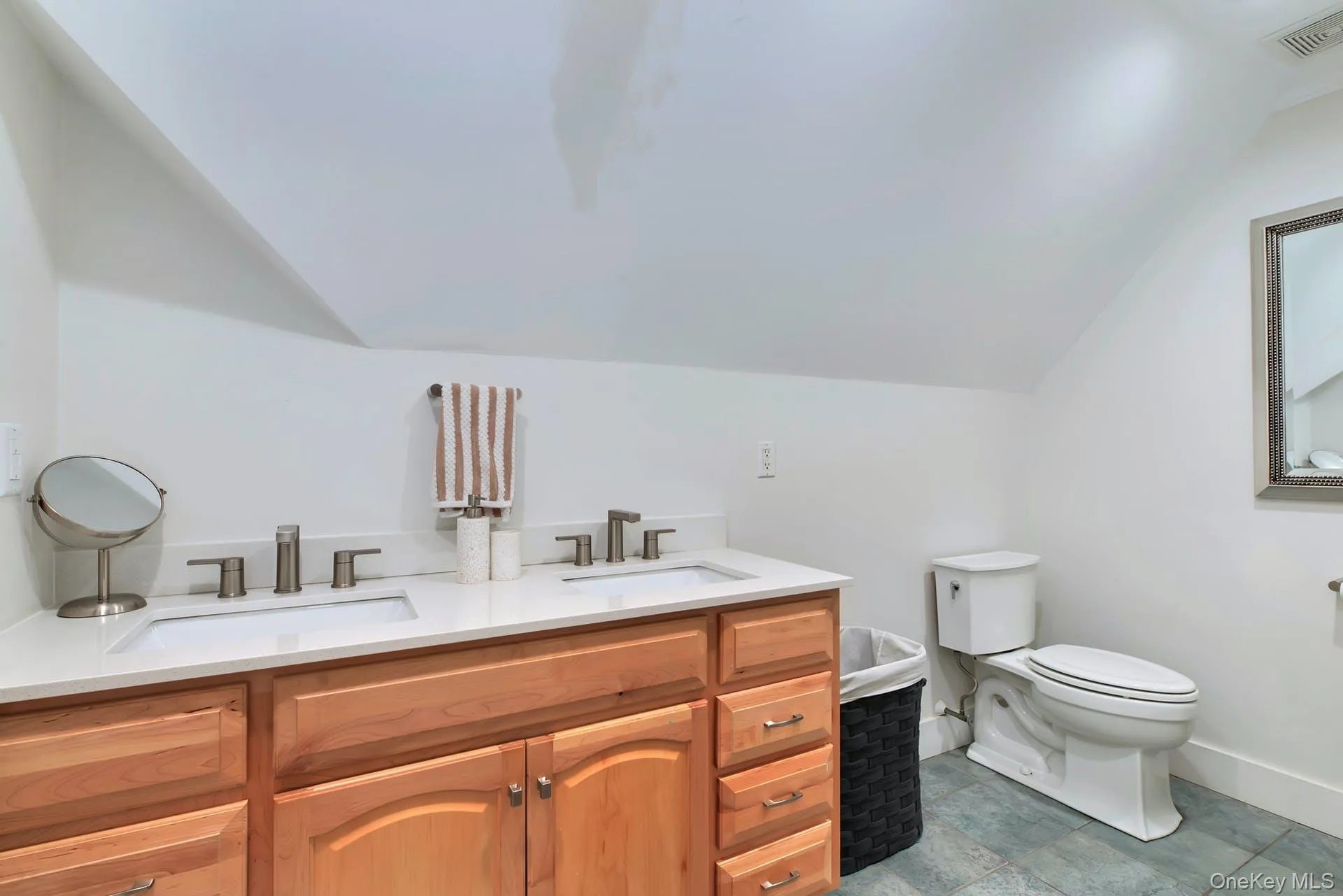 Full bathroom featuring lofted ceiling and double vanity Full bathroom featuring lofted ceiling and double vanity