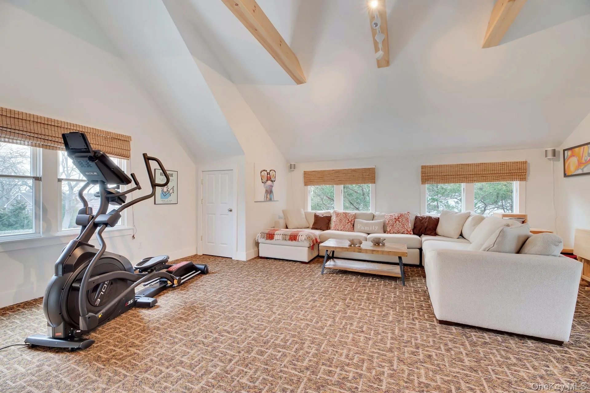 Exercise room featuring high vaulted ceiling, light colored carpet, and beamed ceiling Exercise room featuring high vaulted ceiling, light colored carpet, and beamed ceiling