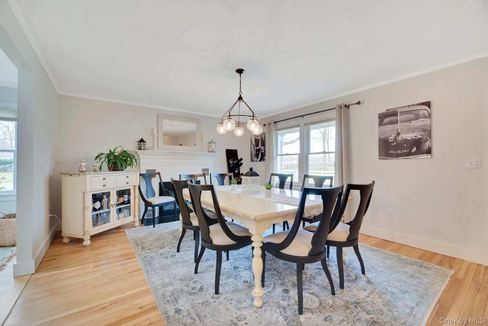 Dining space with light wood-style flooring, ornamental molding, and a chandelier Dining space with light wood-style flooring, ornamental molding, and a chandelier