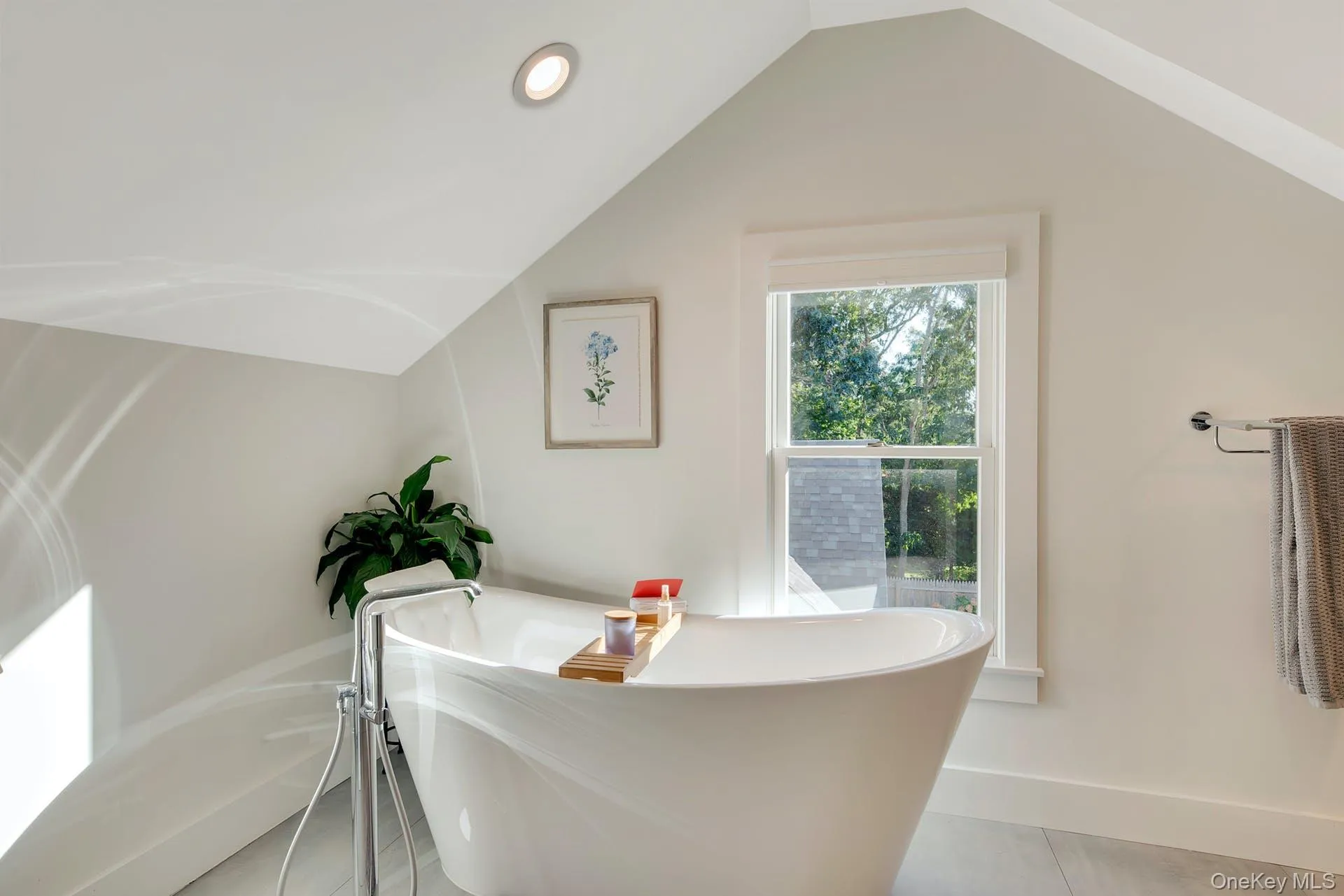 Bathroom with a freestanding bath, lofted ceiling, and recessed lighting Bathroom with a freestanding bath, lofted ceiling, and recessed lighting