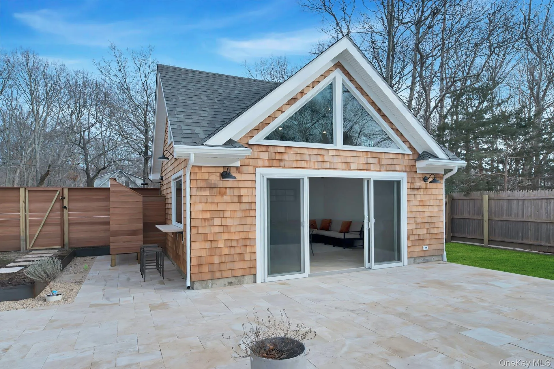 Rear view of property with a gate, a fenced backyard, roof with shingles, and a patio Rear view of property with a gate, a fenced backyard, roof with shingles, and a patio