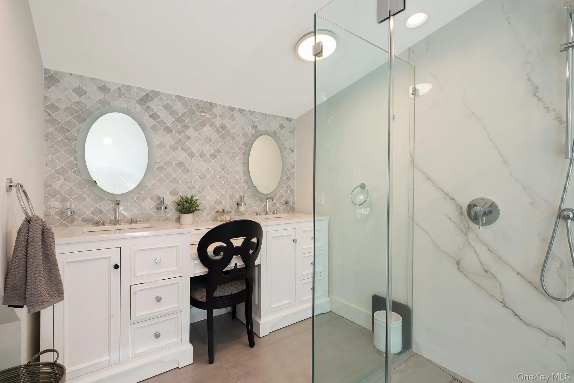 Full bath with a marble finish shower, double vanity, and backsplash Full bath with a marble finish shower, double vanity, and backsplash
