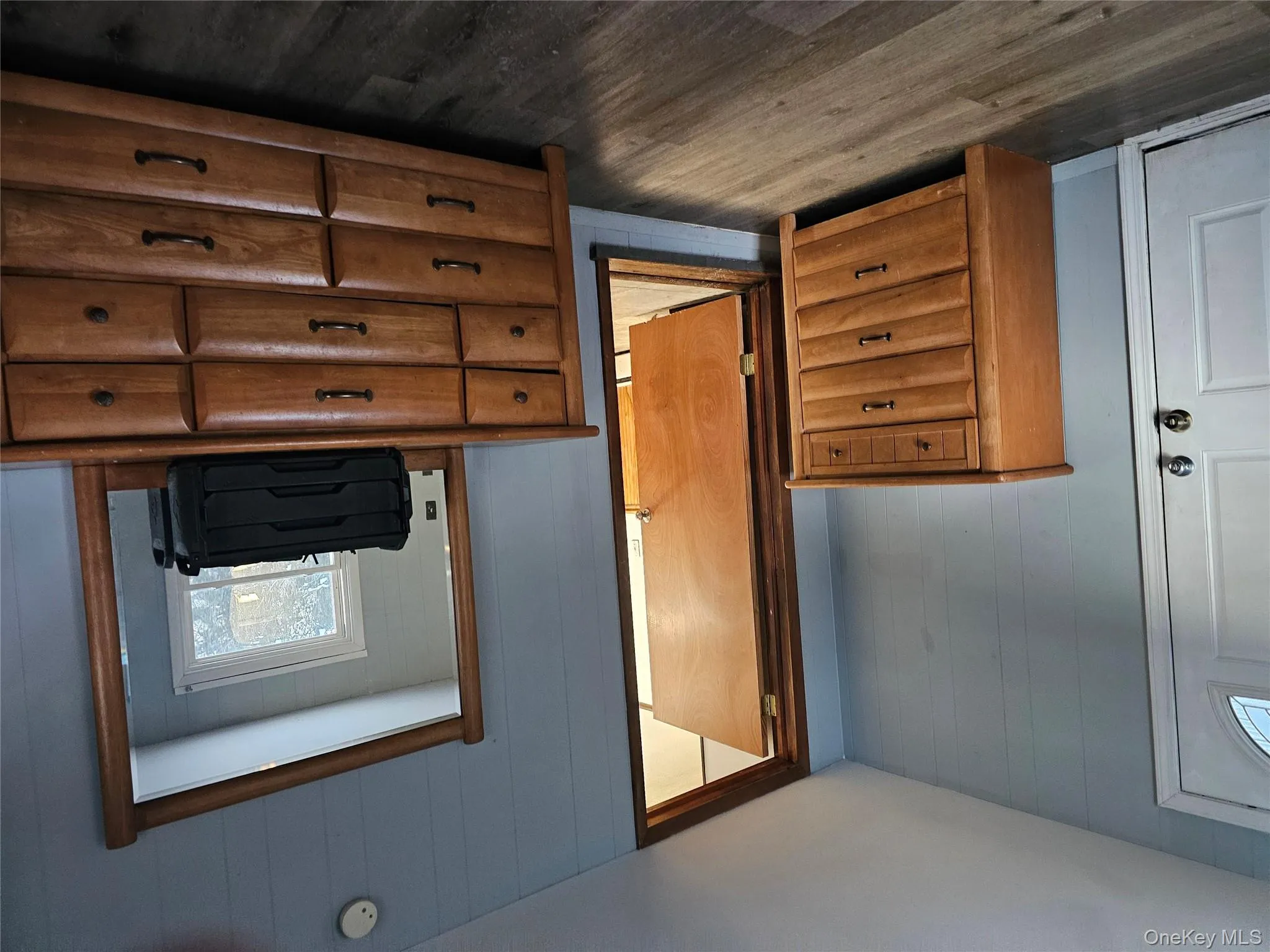 Bedroom featuring multiple windows, wood walls, and dark wood finished floors Bedroom featuring multiple windows, wood walls, and dark wood finished floors