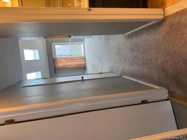 Hallway featuring light carpet and a skylight Hallway featuring light carpet and a skylight