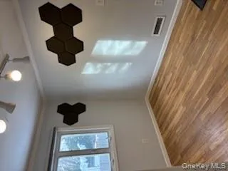 Unfurnished room with ornamental molding, rail lighting, light wood-style floors, and a ceiling fan Unfurnished room with ornamental molding, rail lighting, light wood-style floors, and a ceiling fan