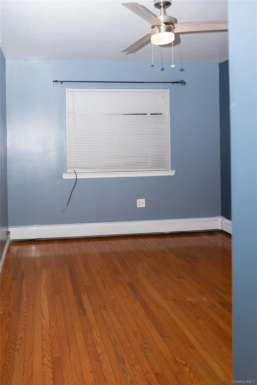 Spare room featuring wood finished floors, a baseboard heating unit, and ceiling fan Spare room featuring wood finished floors, a baseboard heating unit, and ceiling fan