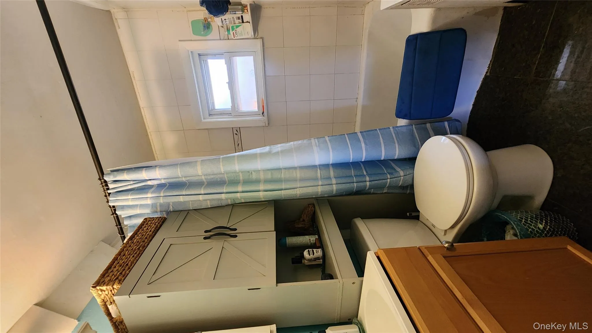 Full bath featuring vanity, dark tile patterned flooring, and shower / bath combo Full bath featuring vanity, dark tile patterned flooring, and shower / bath combo