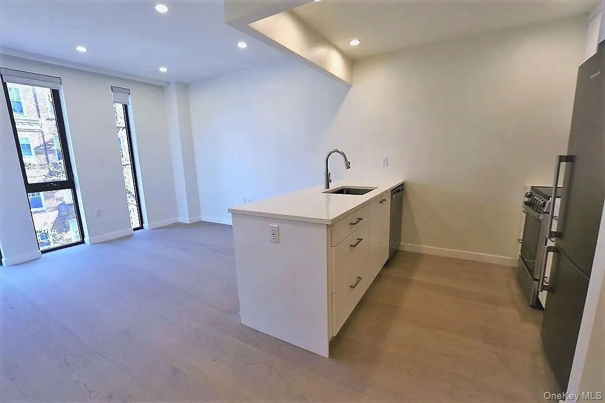 Kitchen with a peninsula, stainless steel appliances, recessed lighting, light wood-type flooring, and white cabinetry Kitchen with a peninsula, stainless steel appliances, recessed lighting, light wood-type flooring, and white cabinetry