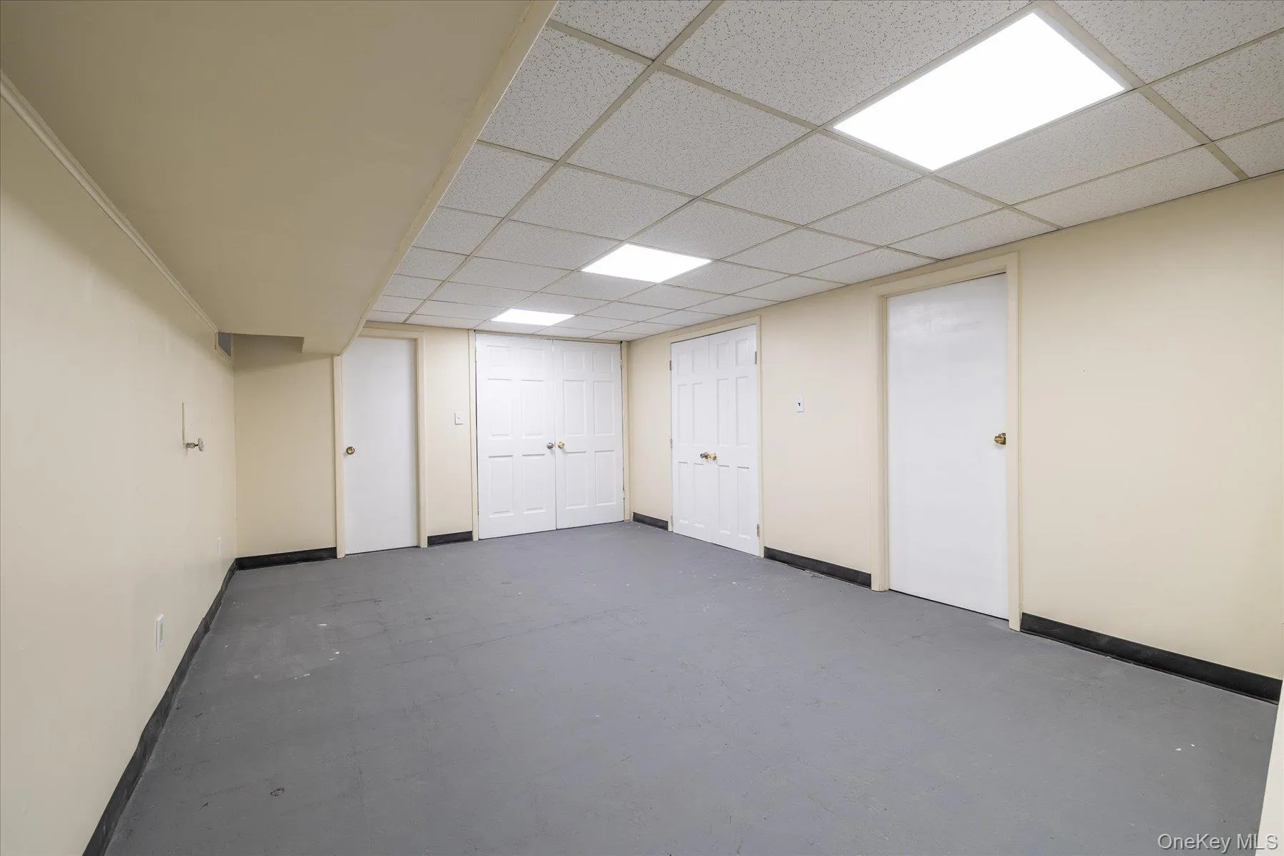 Finished below grade area with baseboards and a drop ceiling Finished below grade area with baseboards and a drop ceiling