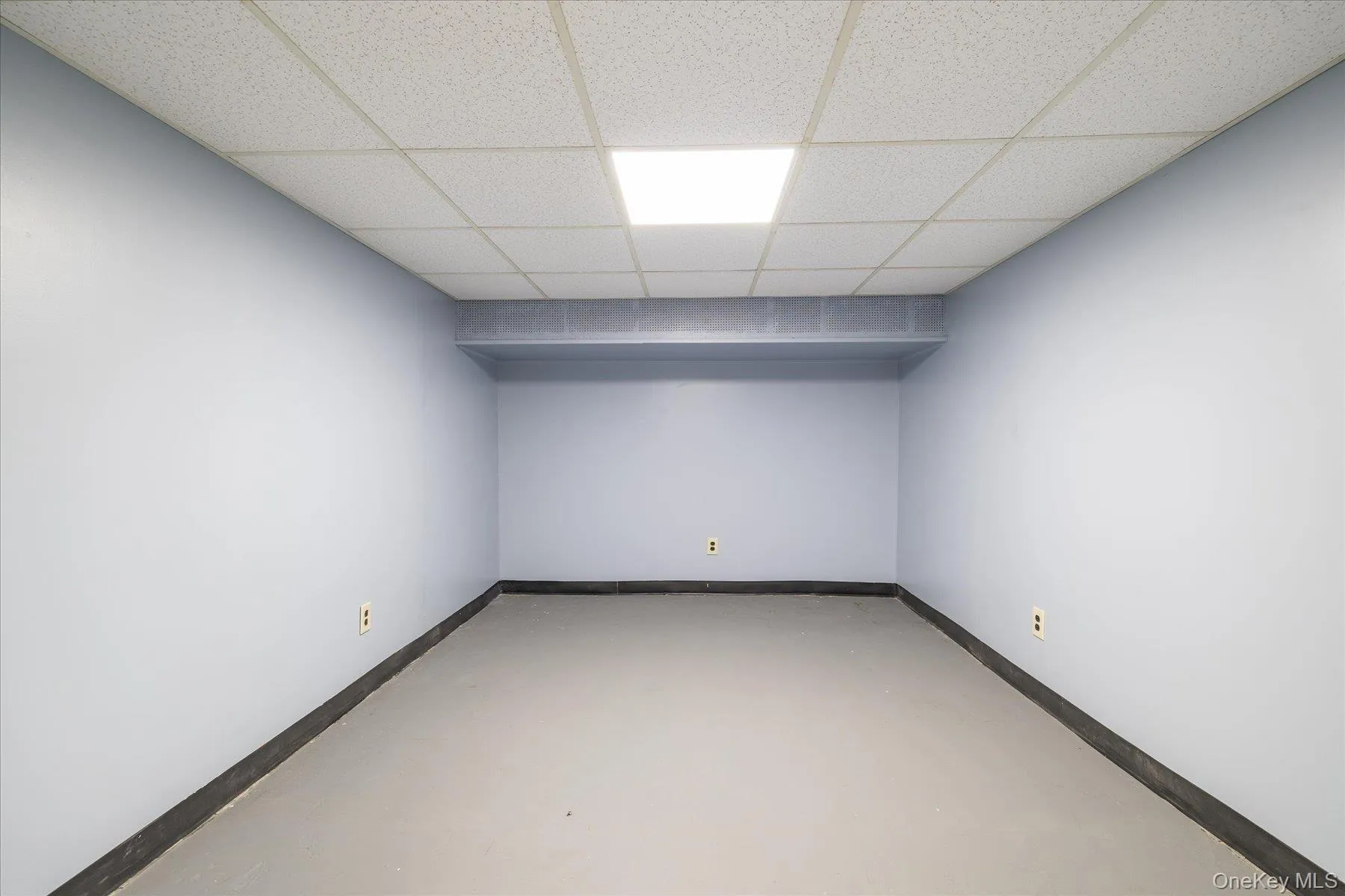 Spare room with finished concrete floors and a drop ceiling Spare room with finished concrete floors and a drop ceiling