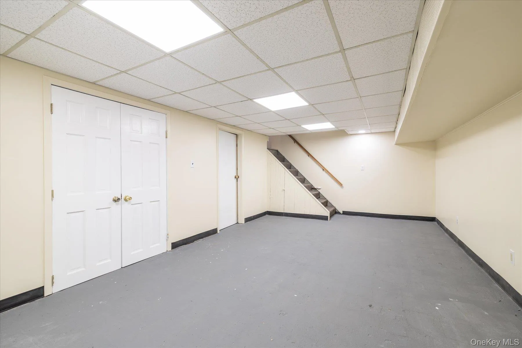 Finished basement with stairway and a paneled ceiling Finished basement with stairway and a paneled ceiling