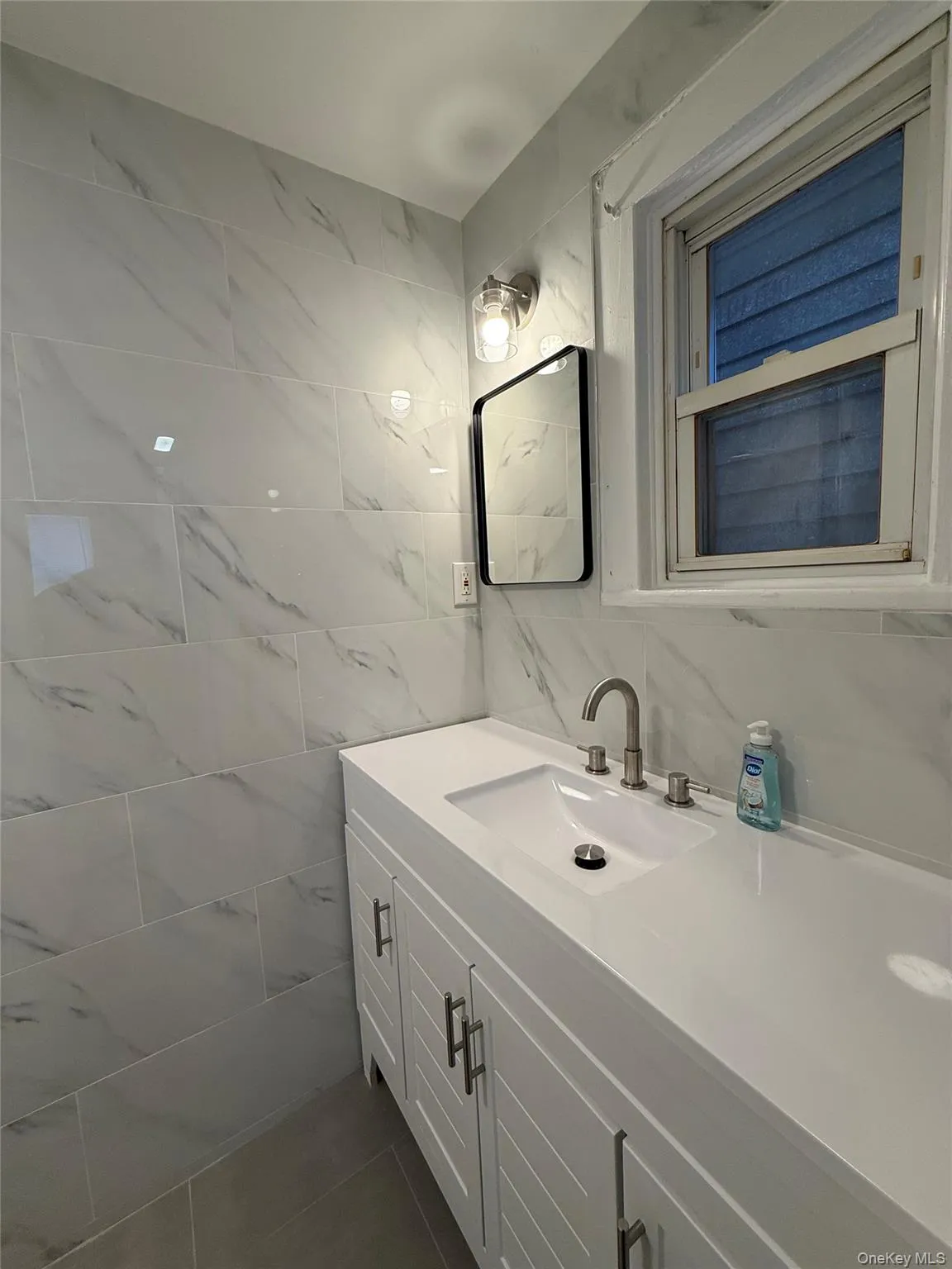 Bathroom featuring vanity, tile walls, and decorative backsplash Bathroom featuring vanity, tile walls, and decorative backsplash