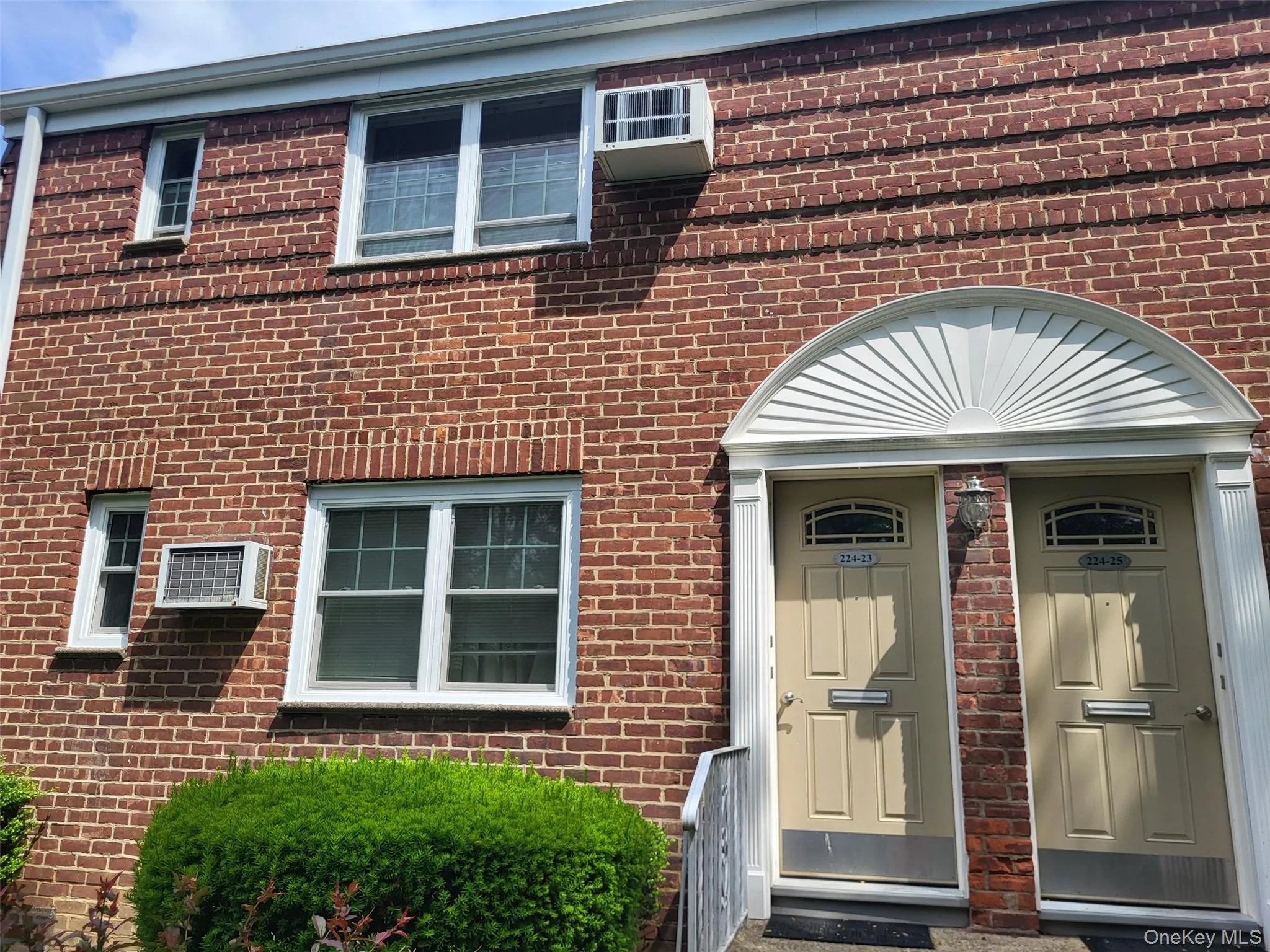 Entrance to property featuring brick siding and a wall mounted AC Entrance to property featuring brick siding and a wall mounted AC