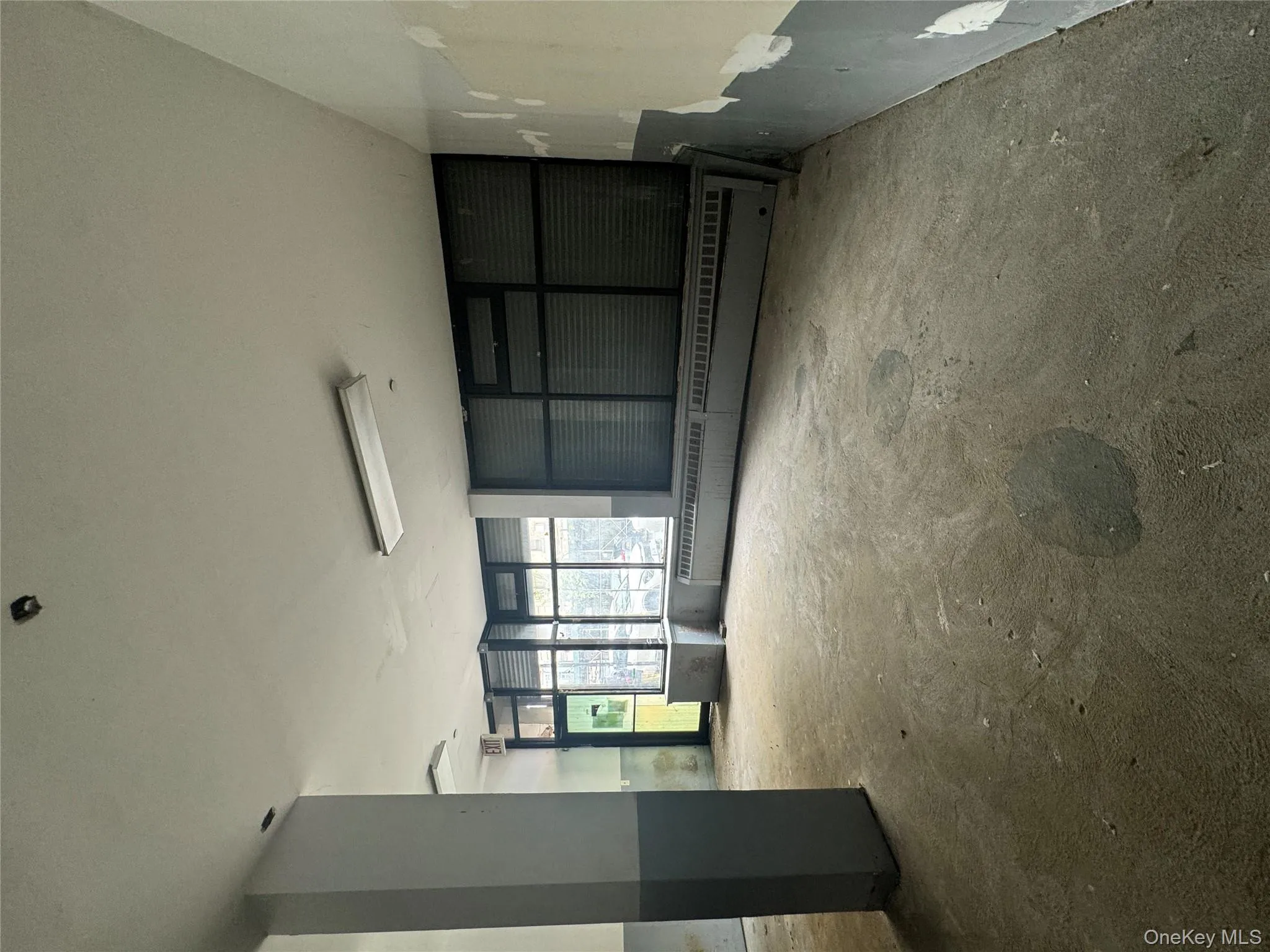 Unfurnished room with unfinished concrete flooring and a baseboard radiator Unfurnished room with unfinished concrete flooring and a baseboard radiator